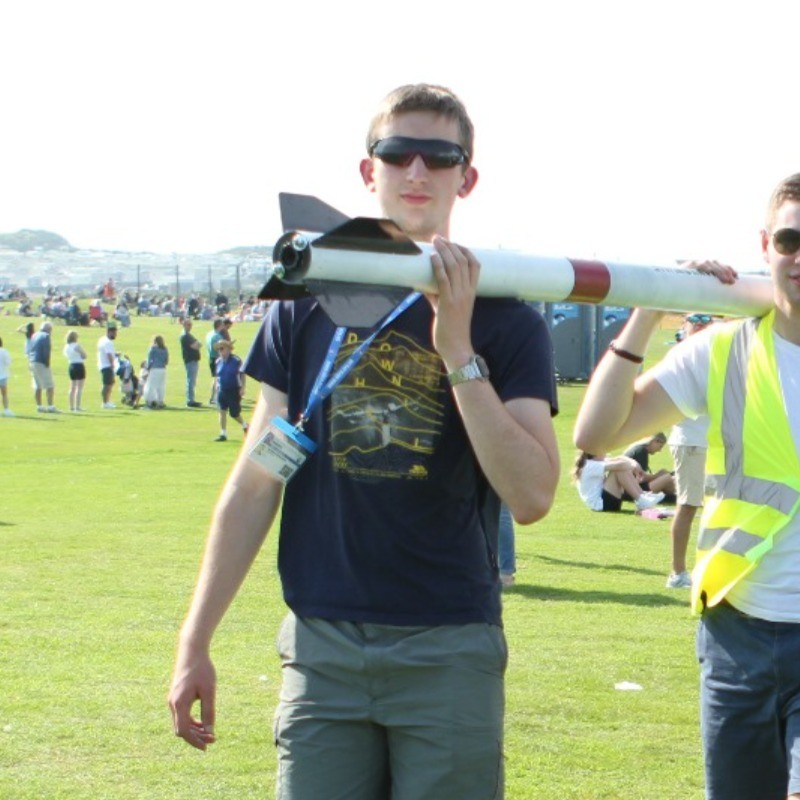 Daniel Edwards carrying a rocket at a launch event