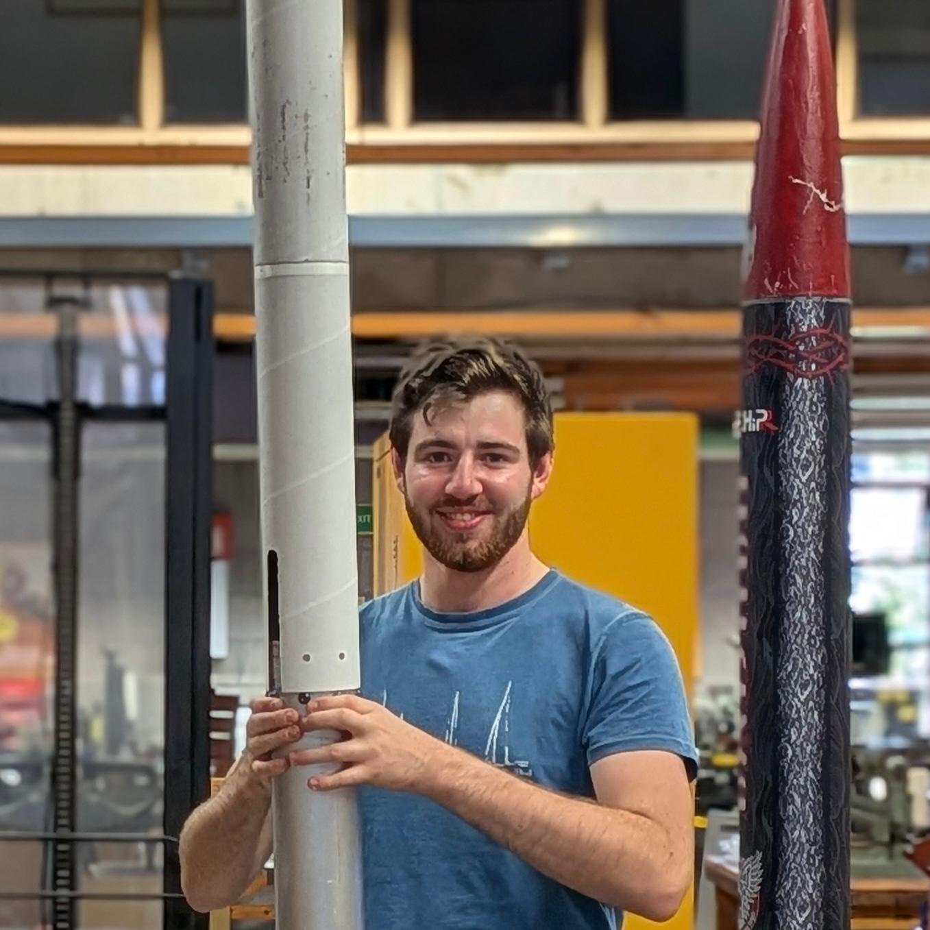 Dylan Cole holding a rocket in the workshop