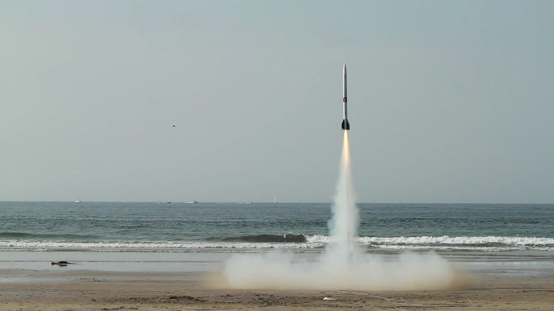 A rocket lifting off from the beach