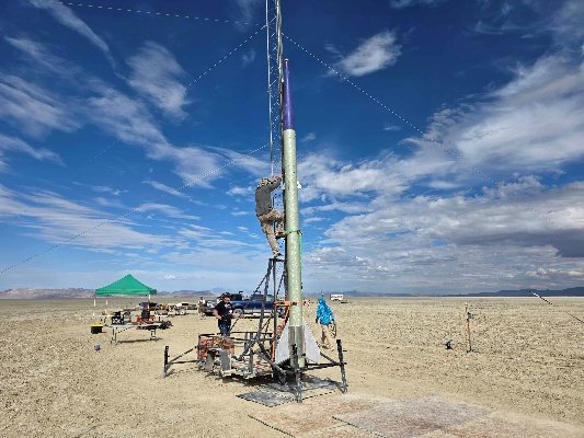 A large rocket being prepared at a launch tower in Black Rock Desert