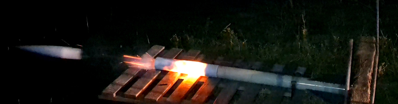 A night-time ground test showing the rocket sections separating with a bright flash